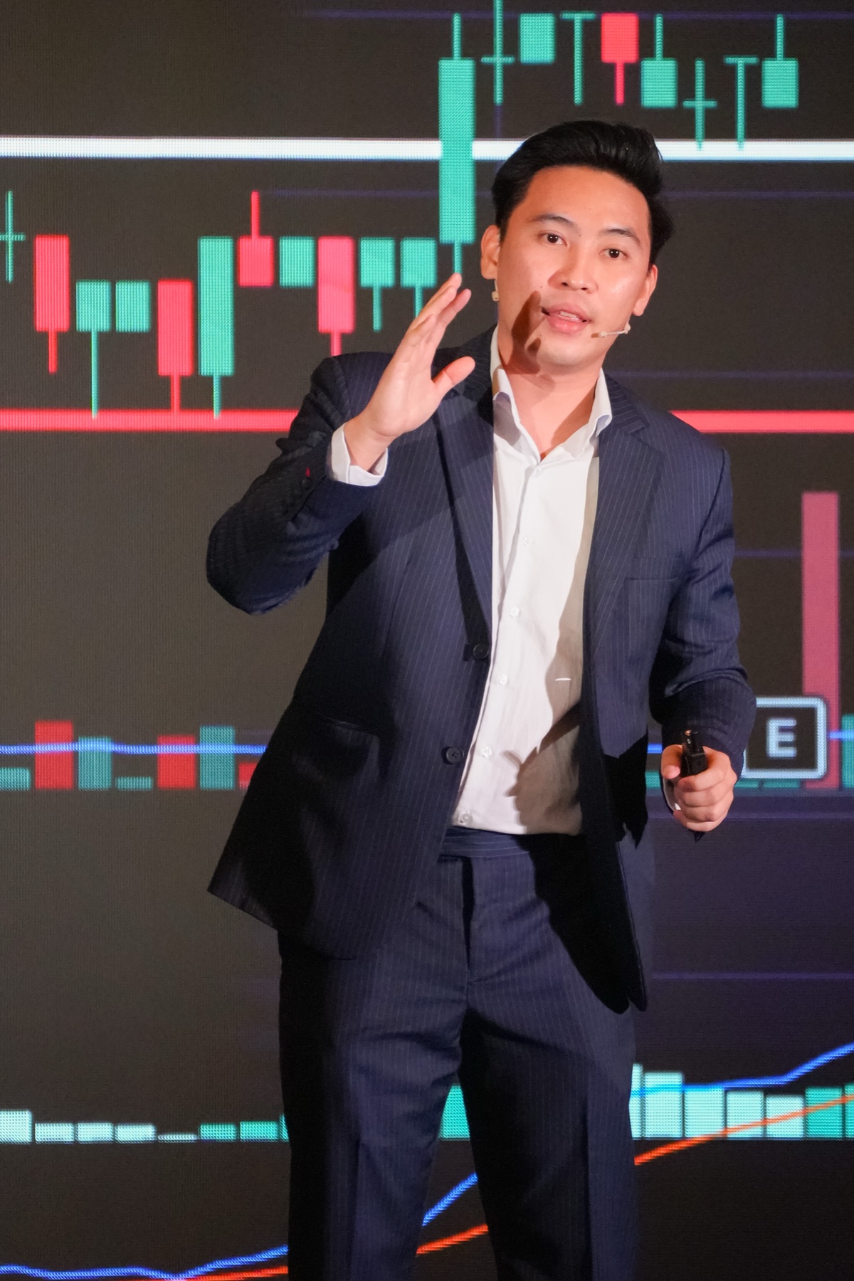 Julio teaching in front of a stock chart during Savwee Investors Day